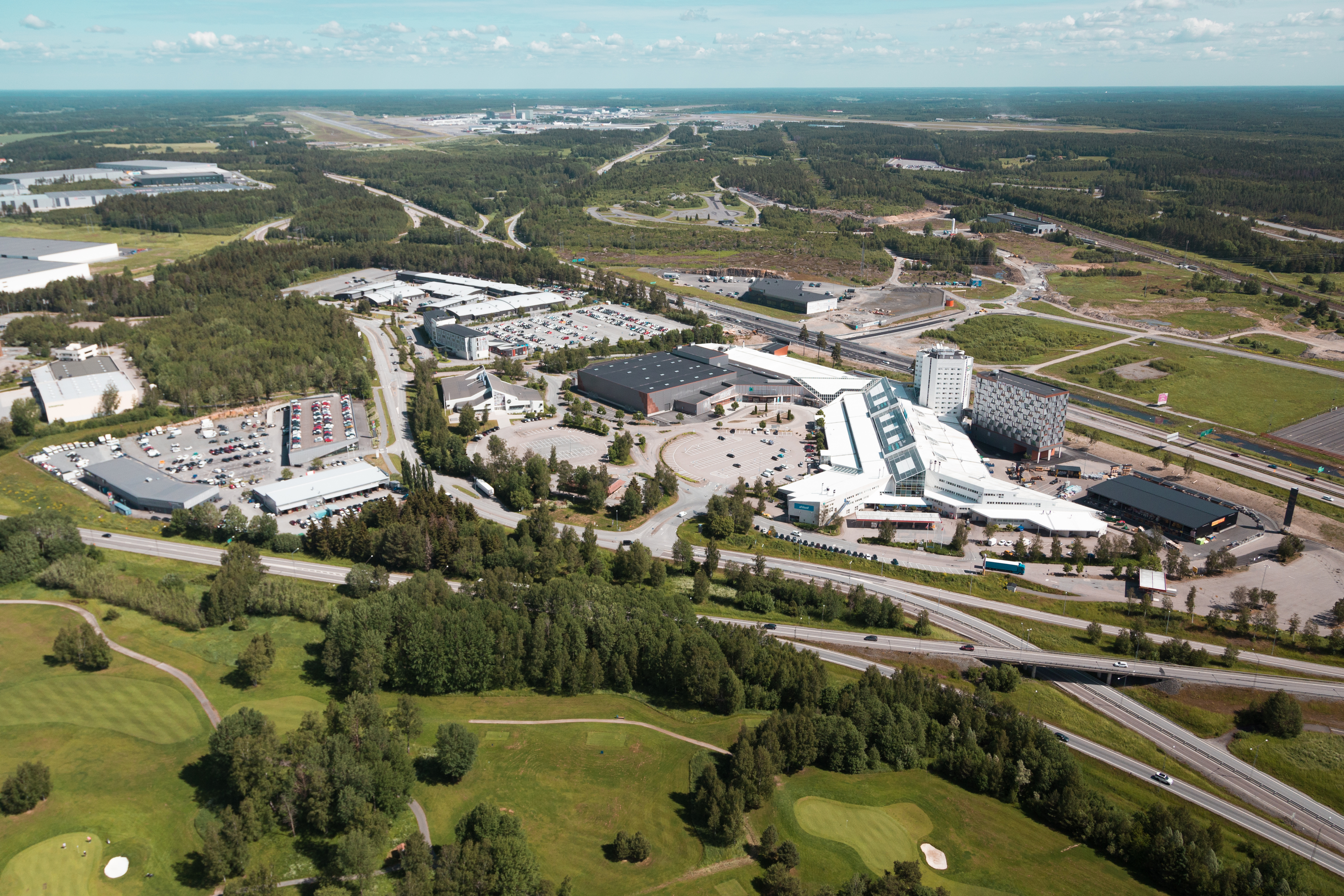 Flygbild över Arlandastad Groups område, Explore Arlandastad, med byggnader och grönområden.